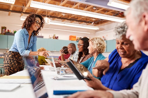 A group of retired seniors learning how to use technology in a class setting