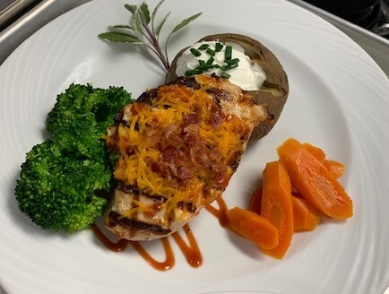 plated grilled chicken, steamed broccoli and carrots and baked potatoe