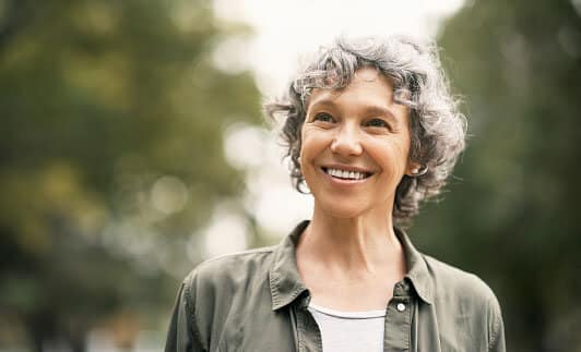 A senior woman smiling while outside