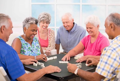 Seniors enjoying g a game of dominos
